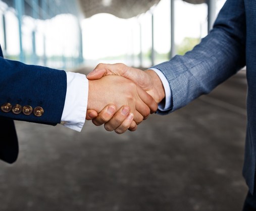 Geschäftlicher Handschlag nach M&A Beratung zum Unternehmenskauf und Unternehmensverkauf durch Planer & Kollegen