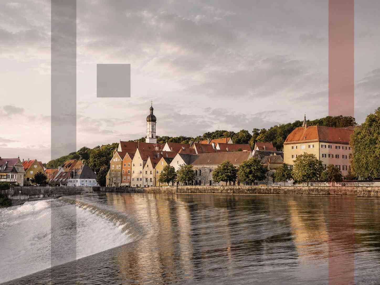 Ein Blick über das Lechwehr auf die Stadtkulisse von Landsberg am Lech, Standort der Insolvenz- und Sanierungsspezialisten von Planer & Kollegen